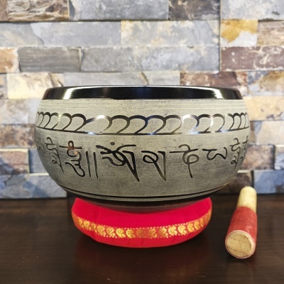 Taça tibetana de metal com inscrições e almofada vermelha