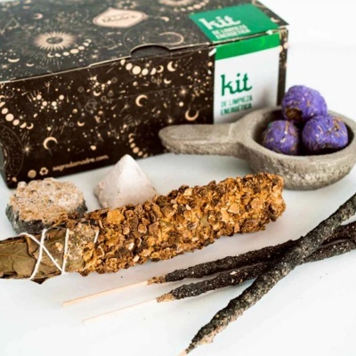 Kit com caixa decorada, maço de sálvia com ervas secas, cristal branco, varetas de incenso e bolas roxas num recipiente cinza