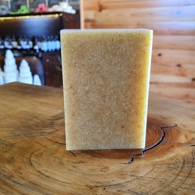 Sabonete bege com textura granulada sobre superfície de madeira rústica