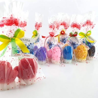 Sabonetes coloridos em forma de conchas embalados em celofane com laços coloridos e etiquetas