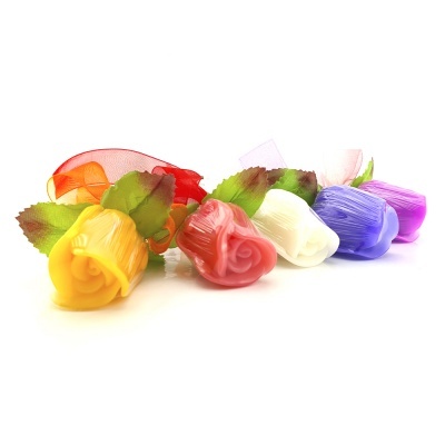 Rosas artificiais coloridas com folhas verdes e laço de fita