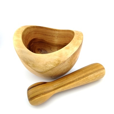 Pilão e almofariz em madeira clara com textura natural
