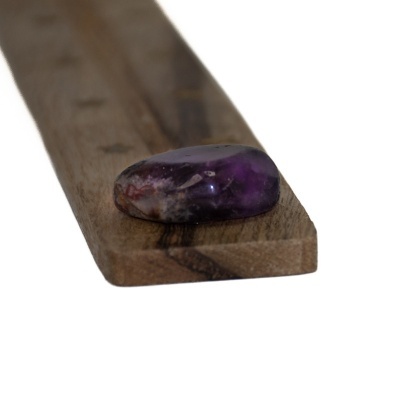 Pedra roxa polida sobre tábua de madeira