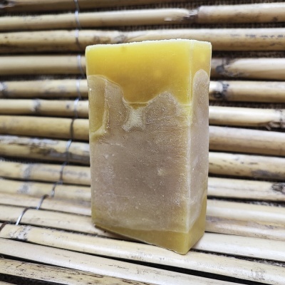 Sabonete artesanal amarelo e bege sobre varas de bambu