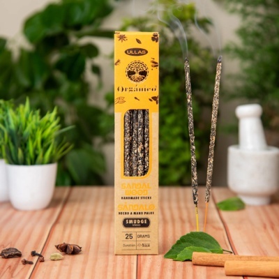 Caixa de incenso Ullas orgânico de sândalo com bastões acesos sobre mesa de madeira