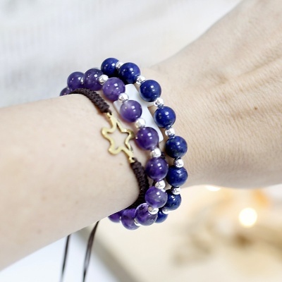 Pulseiras de contas roxas e azuis com pulseira trançada e pendente em estrela dourada no pulso