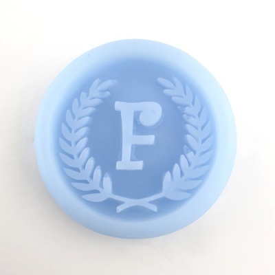 Molde de silicone azul claro com letra F e folhas de louro em relevo