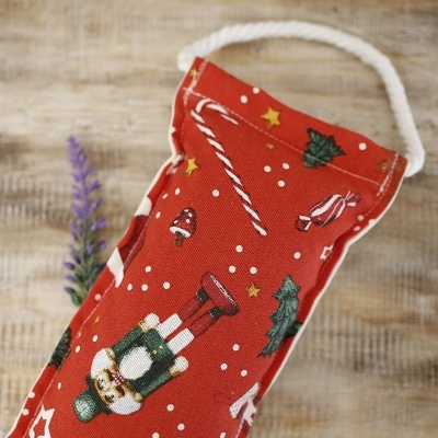 Saco têxtil vermelho natalício com padrões coloridos e pega de corda