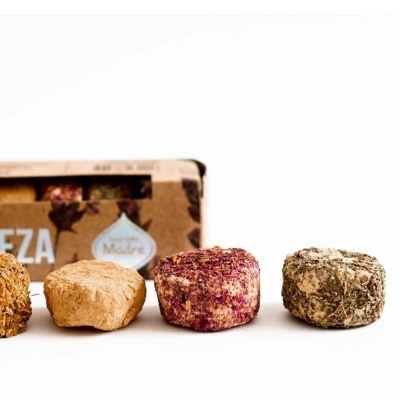 Quatro queijos pequenos variados com embalagem de papel castanho ao fundo