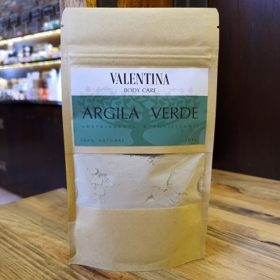 Pacote de argila verde Valentina Body Care em saco de papel kraft sobre mesa de madeira