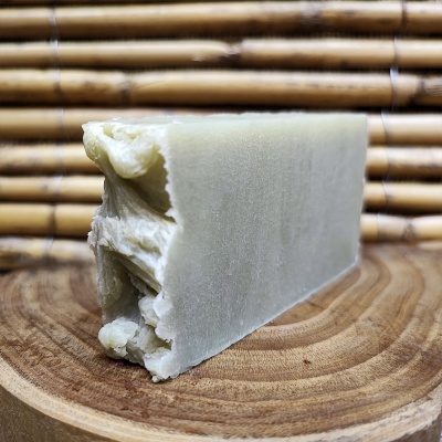 Barra de sabão artesanal creme sobre madeira com fundo de bambu