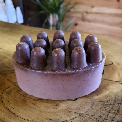 Sabonete marrom oval com protuberâncias em madeira