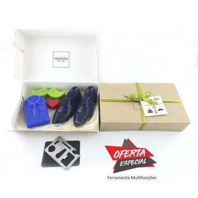 Caixa com sabonetes em forma de camisa, sapatos, flor e coração junto a caixa fechada com fita e cartão