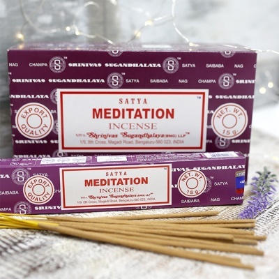 Caixas roxas de incenso Satya Meditation com paus de incenso marrons sobre tecido