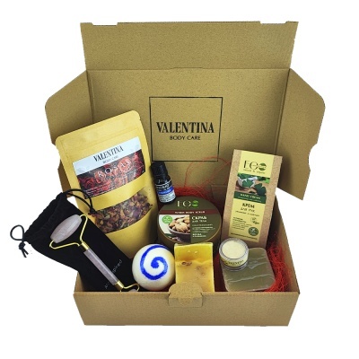Caixa Valentina Body Care com produtos de cuidado corporal, incluindo rolo massageador, sabonete, óleo e creme.