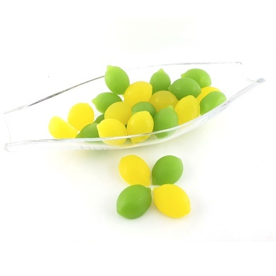 Fruteira de vidro transparente com amêndoas decorativas verdes e amarelas