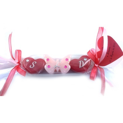 Chocolates em forma de coração e borboleta embalados com laços e etiqueta vermelha