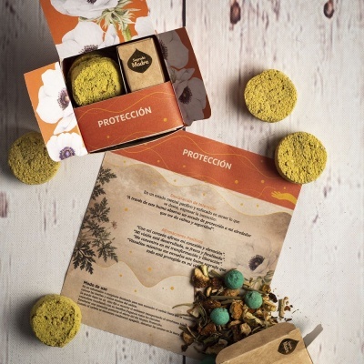 Sabões ou pastilhas amarelas e embalagem com texto em espanhol sobre fundo de madeira clara