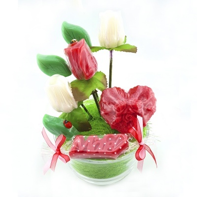 Arranjo decorativo com flores artificiais vermelhas e brancas, folhas verdes e base transparente com musgo