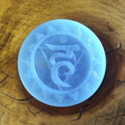 Disco azul translúcido com símbolo gravado em relevo sobre madeira