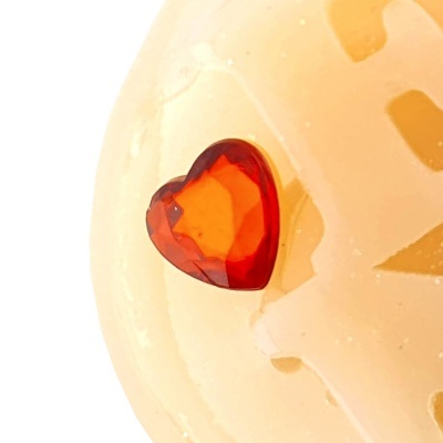 Pedra vermelha em forma de coração numa superfície creme esculpida