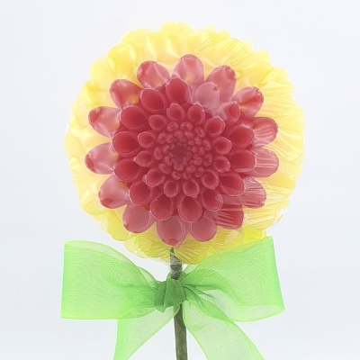 Doce em forma de flor vermelha e amarela com fita verde