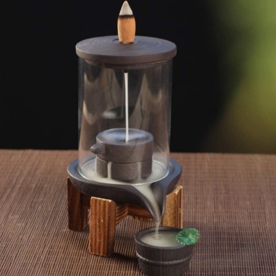 Incensário em vidro e madeira com suporte e tigela castanha, com incenso e água a derramar