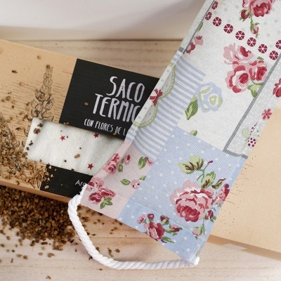 Saco térmico floral azul e vermelho com embalagem de cartão e grãos dispersos