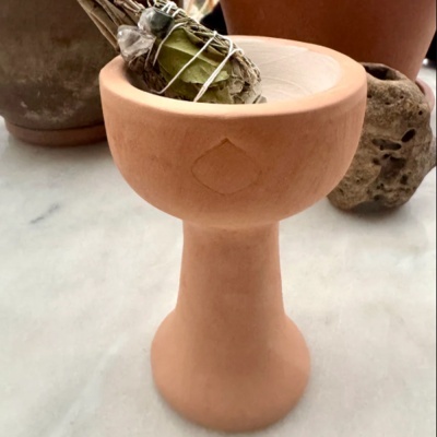 Recipiente em terracota alto com feixe de folhas secas e pedras