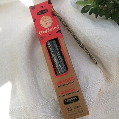 Caixa de incenso orgânico ULLAG gerânio com texto e incenso à parte sobre pano branco
