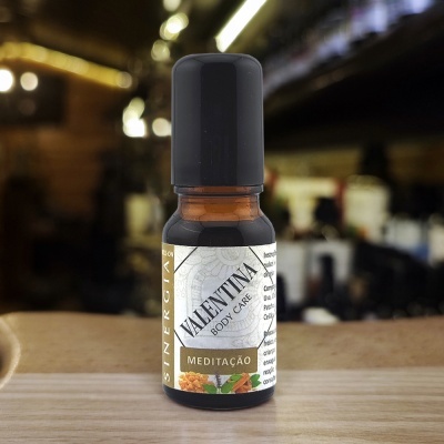 Frasco pequeno âmbar com tampa preta e rótulo branco com texto Valentina Body Care Meditação