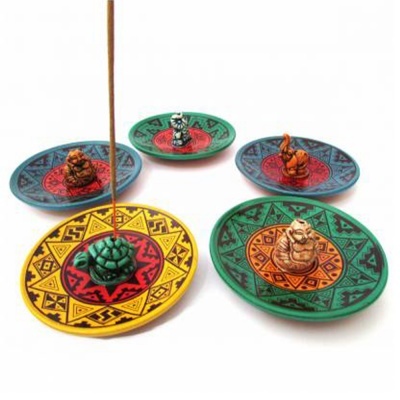 Incensários circulares em cerâmica com estátuas de Buda no centro e padrões tribais coloridos.