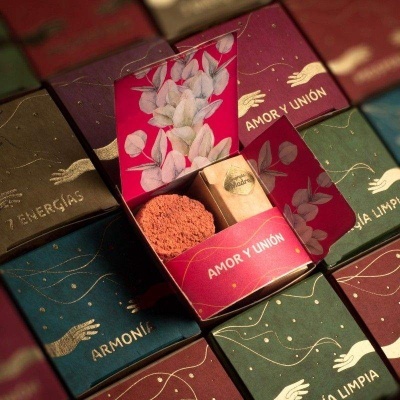 Caixas coloridas para produtos com texto e ilustrações, uma aberta mostrando sabão e papel