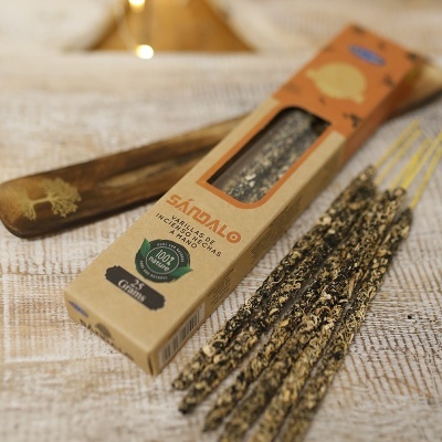 Embalagem de vareta de incenso de sândalo com suporte de madeira decorado, sobre mesa de madeira clara