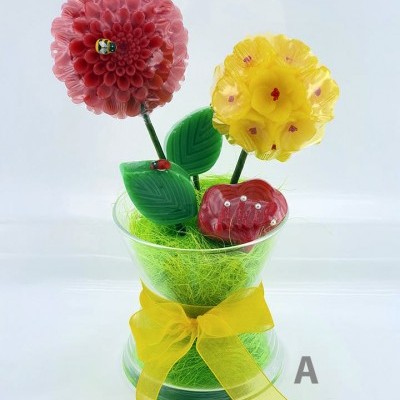 Arranjo de flores e frutas em vidro num vaso transparente com laço amarelo