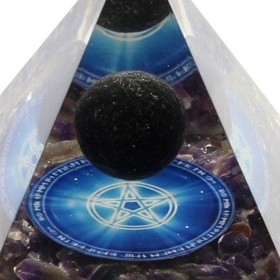 Pirâmide de cristal com esfera negra suspensa e pentagrama azul na base