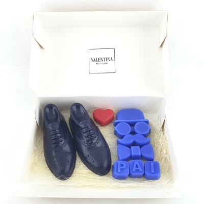 Caixa branca com sapatos de couro azul, figura azul, blocos com letras PAI e coração vermelho