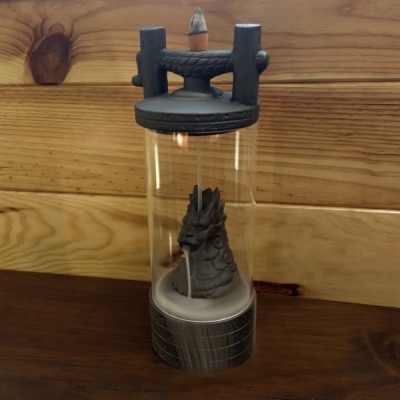 Recipiente transparente com figura escultórica cinza em fundo de madeira