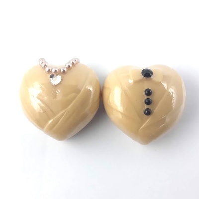 Dois chocolates em forma de coração com decoração e fundo branco