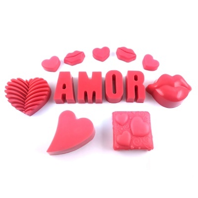 Objetos decorativos vermelhos com corações, lábios e palavra AMOR sobre fundo branco