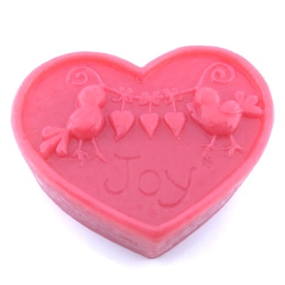 Sabonete rosa em forma de coração com pássaros e a palavra Joy