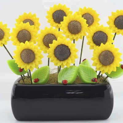 Arranjo decorativo com flores amarelas simulando girassóis em vaso preto