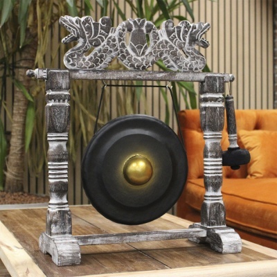 Gongue negro e dourado em estrutura de madeira esculpida decorativa