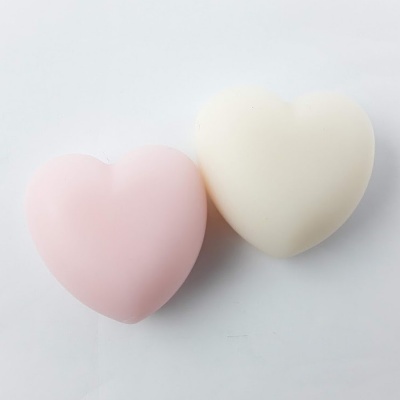 Dois sabonetes em forma de coração, rosa claro e branco