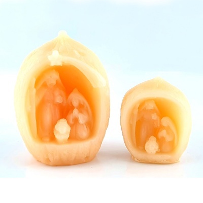 Duas velas em forma de presépio com figuras sacras em tons bege e laranja