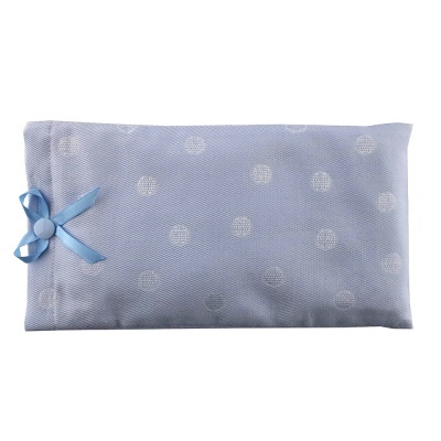 Almofada retangular azul claro com padrão de círculos brancos e laço azul