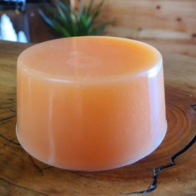 Barra de sabonete cor pêssego em superfície de madeira