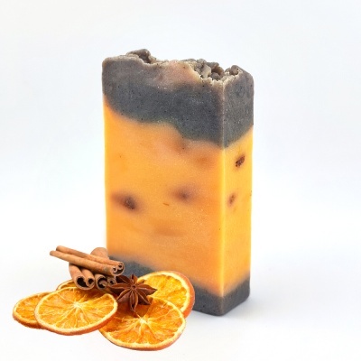 Sabonete artesanal cinza e laranja com especiarias secas e fatias de laranja