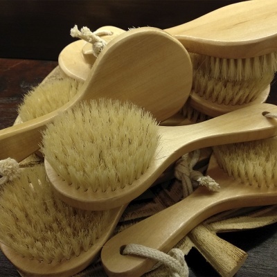 Várias escovas de madeira com cerdas claras e cabos com cordão