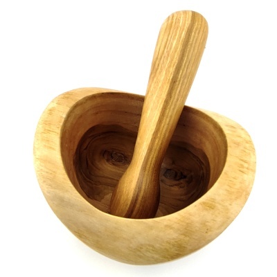 Pilão e almofariz de madeira clara sobre fundo branco